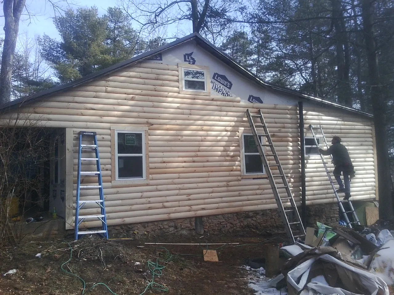 Ladders set against fresh log siding during an exterior remodel in Grinnell