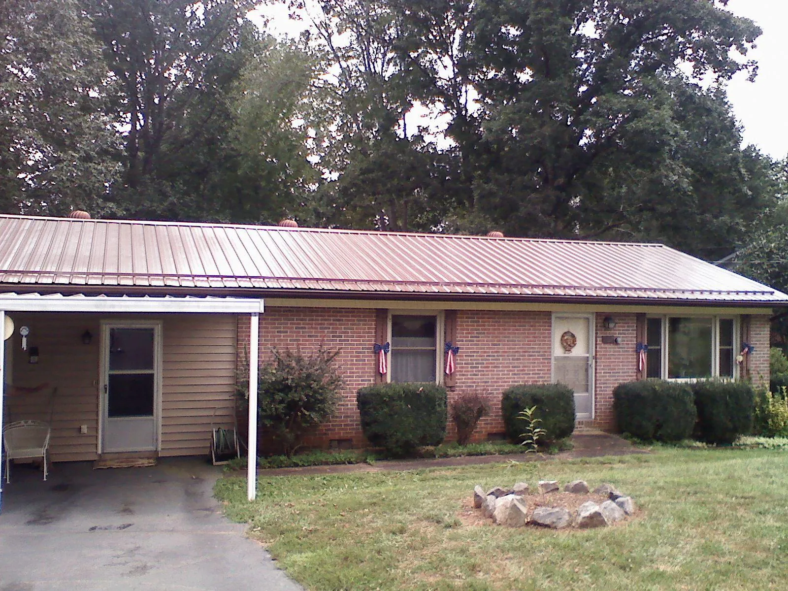 Bronze metal roof and carport on a brick ranch home — Roof Repair work by our crew in Grinnell