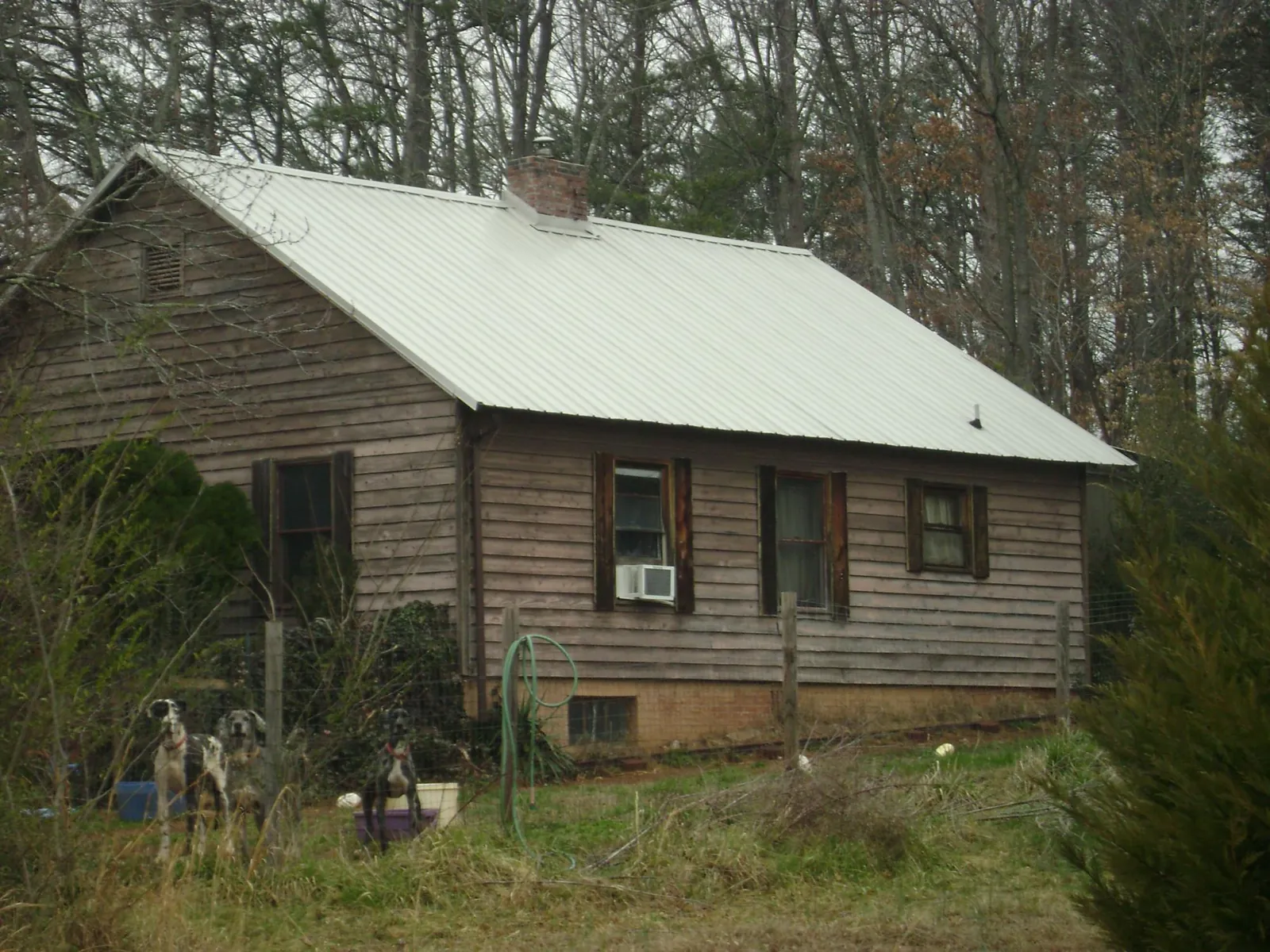 White metal roof on an old wood sided farmhouse, from a Metal Roof Installation job in Grinnell